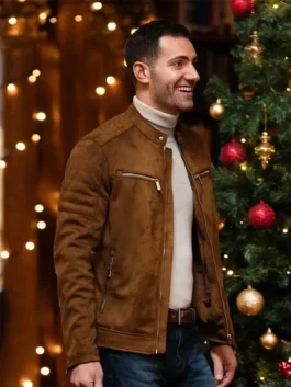 Garrett Marcantel smiling next to a Christmas tree wearing a brown suede café racer jacket over a beige turtleneck