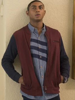 Steven Silver as Marcus Cole wearing a maroon and navy two-tone bomber jacket and a striped chambray shirt