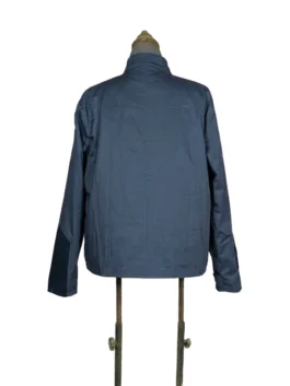 Rear view of the dark blue Steve Rogers lightweight fabric jacket from Captain America: The Winter Soldier, displayed on a vintage tailor's mannequin against a white backdrop.