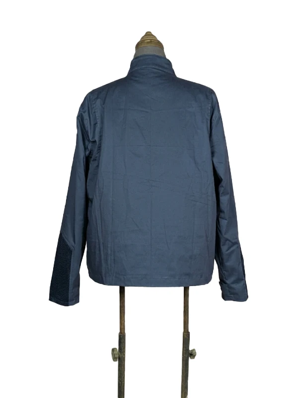Rear view of the dark blue Steve Rogers lightweight fabric jacket from Captain America: The Winter Soldier, displayed on a vintage tailor's mannequin against a white backdrop.