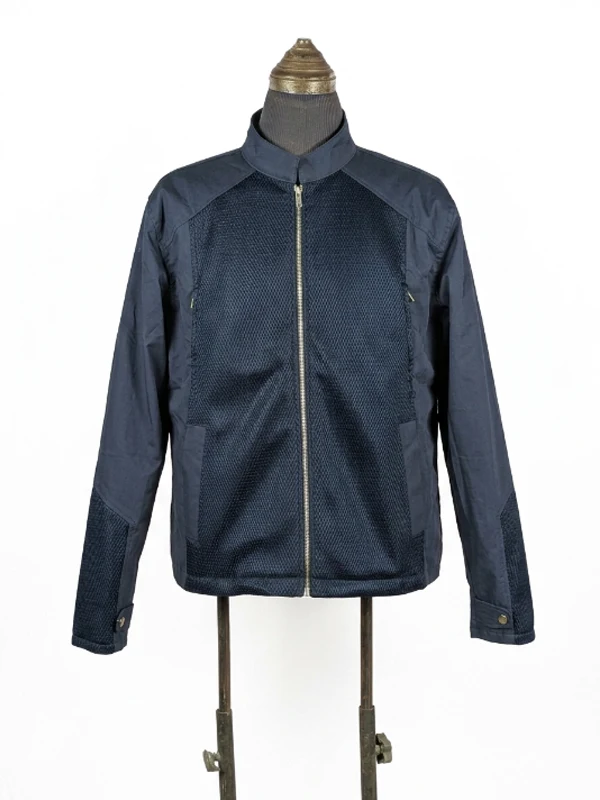 Front view of the screen-accurate Steve Rogers navy blue mesh-panel jacket on a mannequin, highlighting the central silver zipper and stand-up collar.