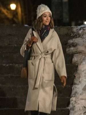Charity Jones wearing the Christmas Unwrapped wool coat in beige. This elegant wrap-style long coat features a belted waist and large front pockets.