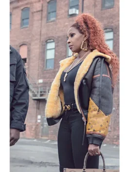 Mary J. Blige as Monet Tejada wearing the iconic Shearling Leather Jacket in Power Book II Ghost. This piece of Mary J. Blige's stylish outerwear features a prominent yellow shearling lining and monogram sleeve.