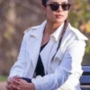 A full-length view of a tailored women's coat with wide lapels and buttoned cuffs.