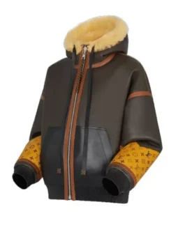 Angled side view of the Mary J. Blige inspired leather jacket. This Power Book II Ghost shearling-lined leather jacket features a brown body, yellow monogram sleeves, and a thick shearling hood, a key part of the Monet Tejada Power Book II outfit.