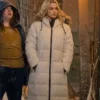 Paris Berelc as Vivian Lee in a long off-white hooded puffer coat standing outside during a winter snowfall