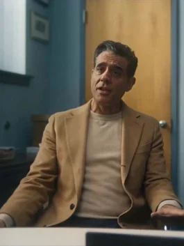 Men's classic camel brown wool trench coat with notched lapel worn over a beige sweater.