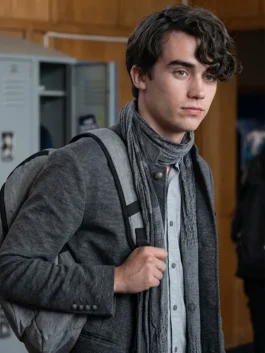 Deaken Bluman as Winston Williams wearing a grey coat, matching scarf, and backpack in a high school hallway