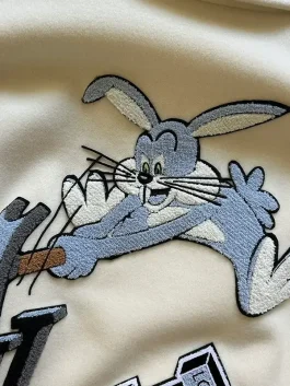Bugs Bunny Louis Vuitton varsity jacket featuring LV logo embroidery and cartoon patches inspired by the Louis Vuitton FW22 varsity jacket collection.