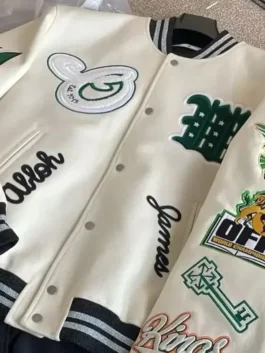 Close-up of a high-quality letterman jacket with ribbed striped cuffs and multiple decorative embroidery details.