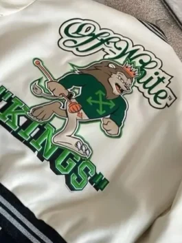 Cream-colored varsity jacket featuring intricate green and black athletic-style patches on the chest and sleeves.