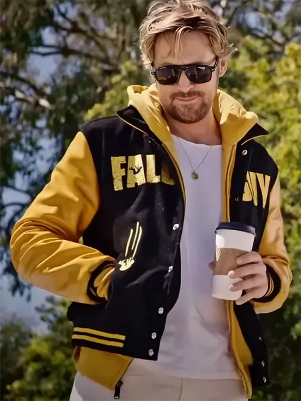 Ryan Gosling wearing The Fall Guy black and yellow varsity jacket with a yellow hoodie and sunglasses. Perfect yellow varsity jacket mens style.