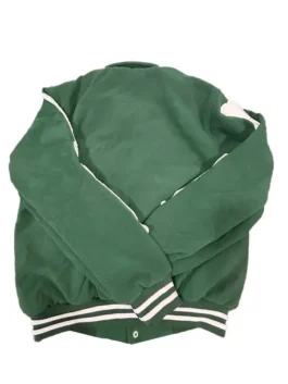 Back view of the green Amiri bomber jacket showing the full sleeves with partial bone appliqués visible near the shoulders and the white-striped ribbed hem and cuffs. This high-end bomber jacket for men is a popular Amiri jacket style.