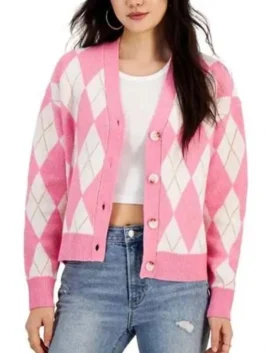 Carrie Preston as Elsbeth, wearing a pink and white argyle cardigan over a ruffled white blouse with a lanyard.