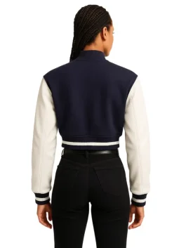 Back view of the navy and cream cropped varsity jacket, showing the solid navy back panel and cream sleeves.
