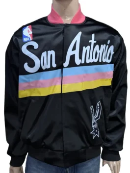 Front view of a San Antonio Spurs warm up jacket for men and women with teal, pink, and yellow stripes and San Antonio script across the chest.