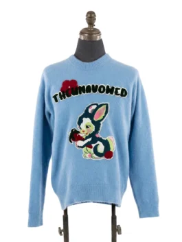 Front view of a pastel blue fuzzy knit crewneck sweater detailed with an arched green text patch and a retro cartoon bunny patch.