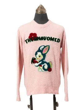 Front view of a light pink fuzzy knit crewneck sweater featuring an arched 