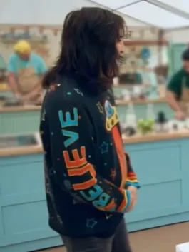 Side view of Noel Fielding wearing the Great British Bake Off Noel alien sweater with a focus on the sleeve's vertical 