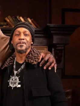 Close-up image of Katt Williams wearing a Fendi Black Jacket with a signature Fendi monogram (logo) collar. He is also wearing a beanie and a large pendant necklace. This highlights the Katt Williams Fendi outfit jacket and Katt Williams Fendi style jacket.