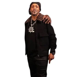 Full-body photo of Katt Williams wearing a black outfit including a Katt Williams Fendi men jacket with a Fendi print collar. This is the Katt Williams Fendi black jacket shown during an interview, showcasing the Katt Williams Fendi designer jacket.
