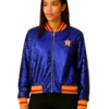 Full-length front view of a woman modeling a dazzling sequin astros jacket. The blue bomber jacket features the Houston Astros star logo on the chest and has red and yellow striped ribbed trim on the collar, waist, and cuffs, perfect for a women's astros jacket look.
