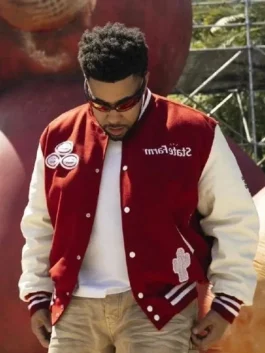 Travis Scott wearing Cactus Jack x State Farm varsity jacket with cactus design and branded front patches.