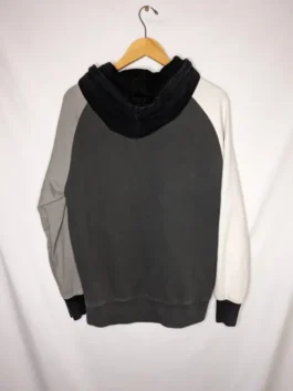Back view of a black teddy fresh color block hoodie on a hanger, featuring black, gray, and white panels.