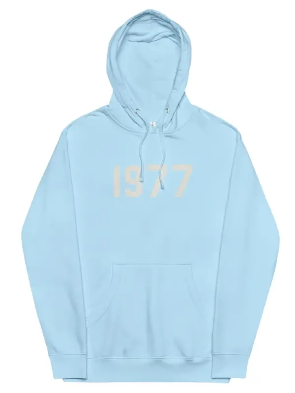 A light blue Fear of God Essentials hoodie with the large numbers "1977" printed faintly in a lighter color on the chest.
