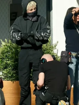 Barry Keoghan in Crime 101 black pullover hoodie styling with metallic grommets on sleeves during filming