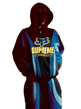 Model in blue and black Supreme Fox Racing Zip Up Hooded Sweatshirt with Pant featuring yellow Supreme Factory Team logo and bold street style design.