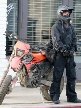 Barry Keoghan spotted in Crime 101 black pullover hoodie while standing beside an orange motorbike during shoot.