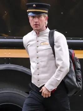 Crime 101 Barry Keoghan concierge outfit showing his stylish cream-colored jacket paired with black trousers.
