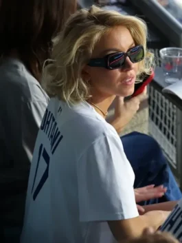 Close-up side view of Sydney Sweeney wearing Dodgers jersey, specifically a white Shohei Ohtani Dodgers jersey with 'OHTANI' and the number '17' clearly visible on the back. She is wearing sunglasses at the Sydney Sweeney Dodgers game outfit.