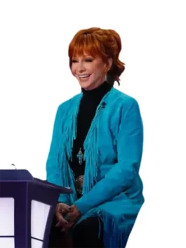 Reba McEntire in the coach chair wearing the The Voice S28 blue fringe coat and a black turtleneck.