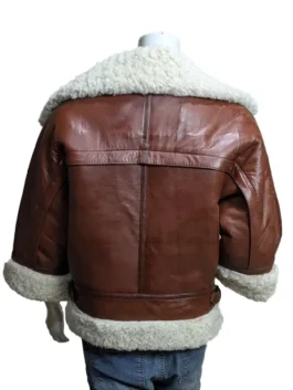Detailed view of the white shearling collar and buckle strap hardware on a brown leather short-sleeved aviator jacket.