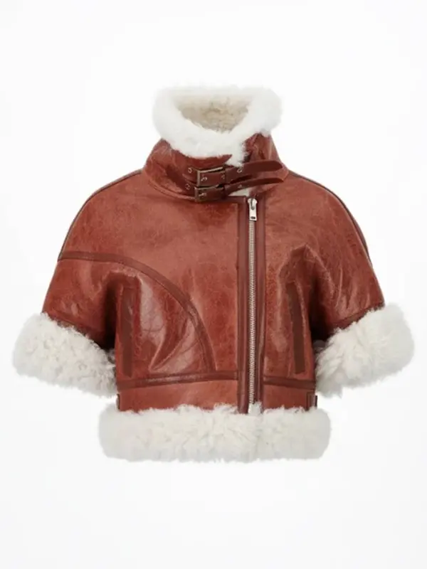 Close-up studio shot of a women’s cropped brown shearling aviator leather jacket with short sleeves, featuring a high collar, zipper closure, and visible white shearling trim.