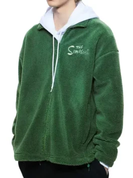 A side view of the back of the green sherpa fleece jacket, showing a large graphic of Homer Simpson emerging from the surrounding green fabric, styled like the famous meme of Homer backing into a hedge or bush.