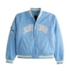 Light blue Detroit Lions varsity bomber jacket with "DETROIT" across the chest and a Lions helmet patch on the left sleeve.