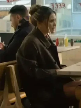 Jingle Bell Heist Olivia Holt Brown Long Coat. Sophia (Olivia Holt) wearing the long brown coat and her hair up, sitting in a diner scene from the movie.