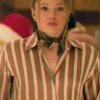 A pink and green striped shirt styled with a neck scarf indoors.