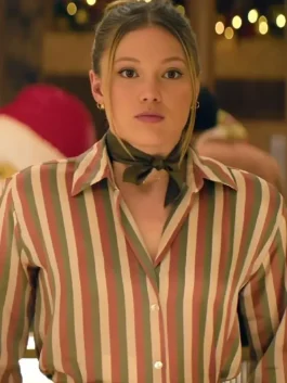 A pink and green striped shirt styled with a neck scarf indoors.