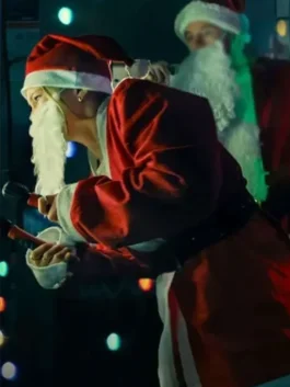 A woman in a red Santa costume leans forward while holding an object in a festive, low-lit setting.