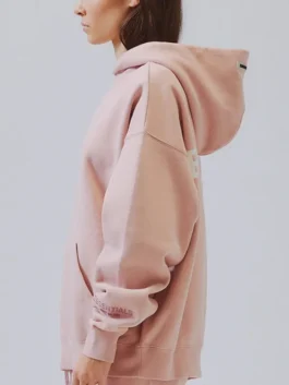 Side profile of the Essentials peach hoodie from Pacsun, showing the sleeve detail and hood. A great loungewear piece.