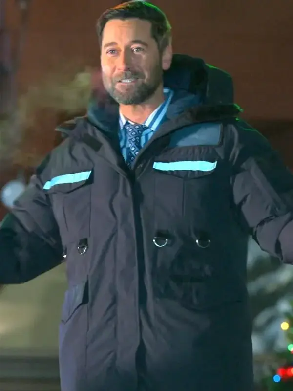 Man wearing a black hooded parka with reflective chest strips in a night outdoor scene.
