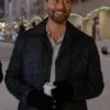 Man wearing a dark black wool coat with a wide collar, standing outdoors in a snowy street at night.