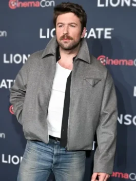 Brandon Sklenar wears The Housemaid 2025 Andrew Winchester jacket. This premium grey wool jacket features a distinct triangular chest pocket.