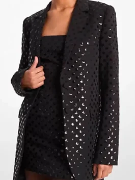 Front view of a black sequin dot blazer with a longline cut and lapel collar, styled over a black outfit.