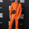 Timothée Chalamet in a bright orange Chrome Hearts suit at the Marty Supreme premiere, featuring a unique black bag.