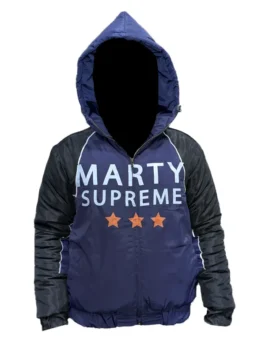 Nikki Glaser on the set of Marty Supreme 2026 wearing an oversized navy blue and black jacket while holding a table tennis paddle.